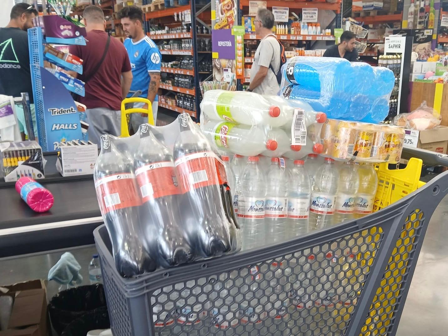 Clienta de Borosa Market con el carro lleno de garrafas de agua Monssalus 8L en caja